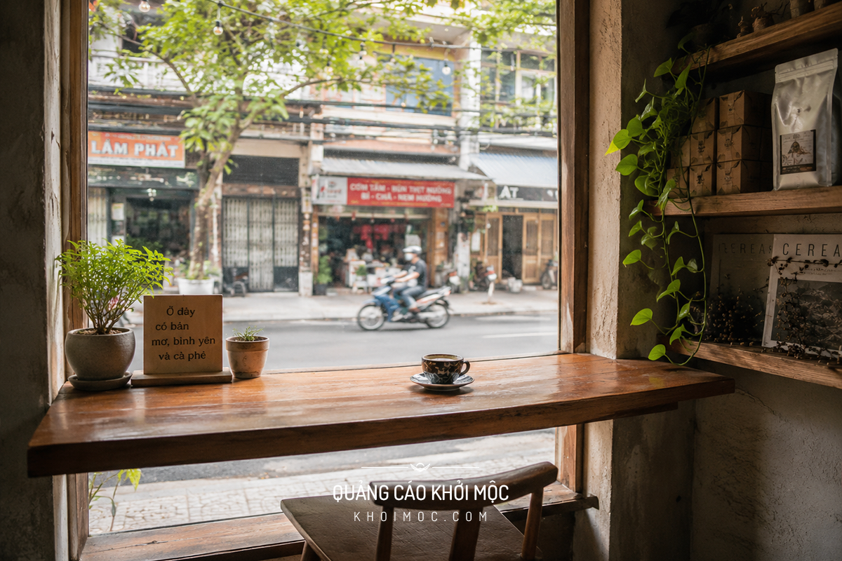 Góc ghế bên cửa sổ kính trong quán cà phê nhỏ nhiều ánh sáng tự nhiên