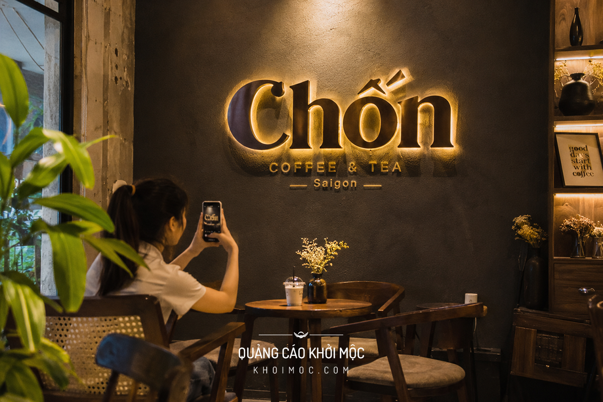 Bức tường check-in gắn chữ nổi tên quán cà phê có đèn hắt